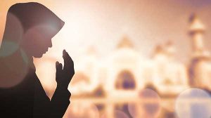 Une femme musulmane portant le voile en train de prier.