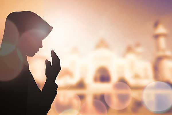 Une femme musulmane portant le voile en train de prier.